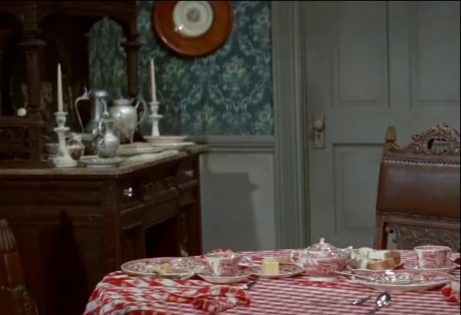 Victorian dining room with a red-and-white checkered tablecloth, half-finished breakfast dishes and silverware, from the Western film Quantrills Raiders (1958).