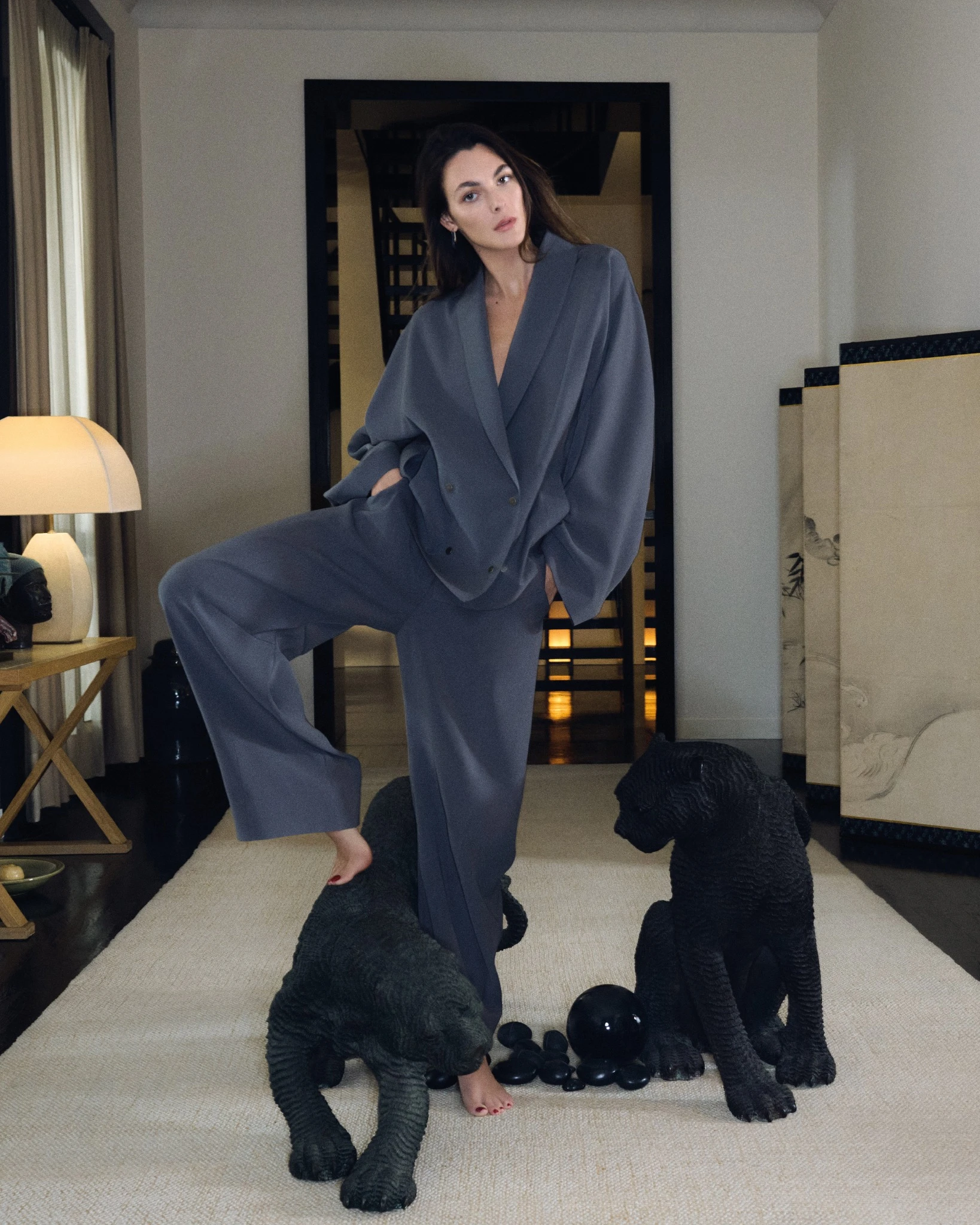 Vittoria Ceretti photographed for the Giorgio Armani Spring Summer 2026 campaign, wearing a fluid tailored suit inside the designer’s Milan residence, surrounded by sculptural artworks.