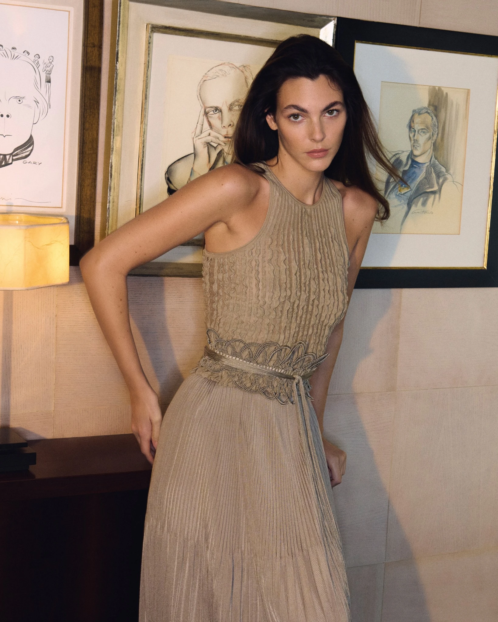 Vittoria Ceretti photographed for the Giorgio Armani Spring Summer 2026 campaign, wearing a softly pleated sleeveless dress inside the designer’s Milan residence, framed by artworks