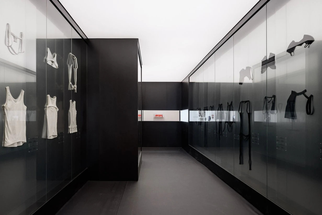 Installation view of the Helmut Lang SANCE DE TRAVAIL 1986–2005 exhibition at MAK Vienna, showing minimalist glass displays and archival garments