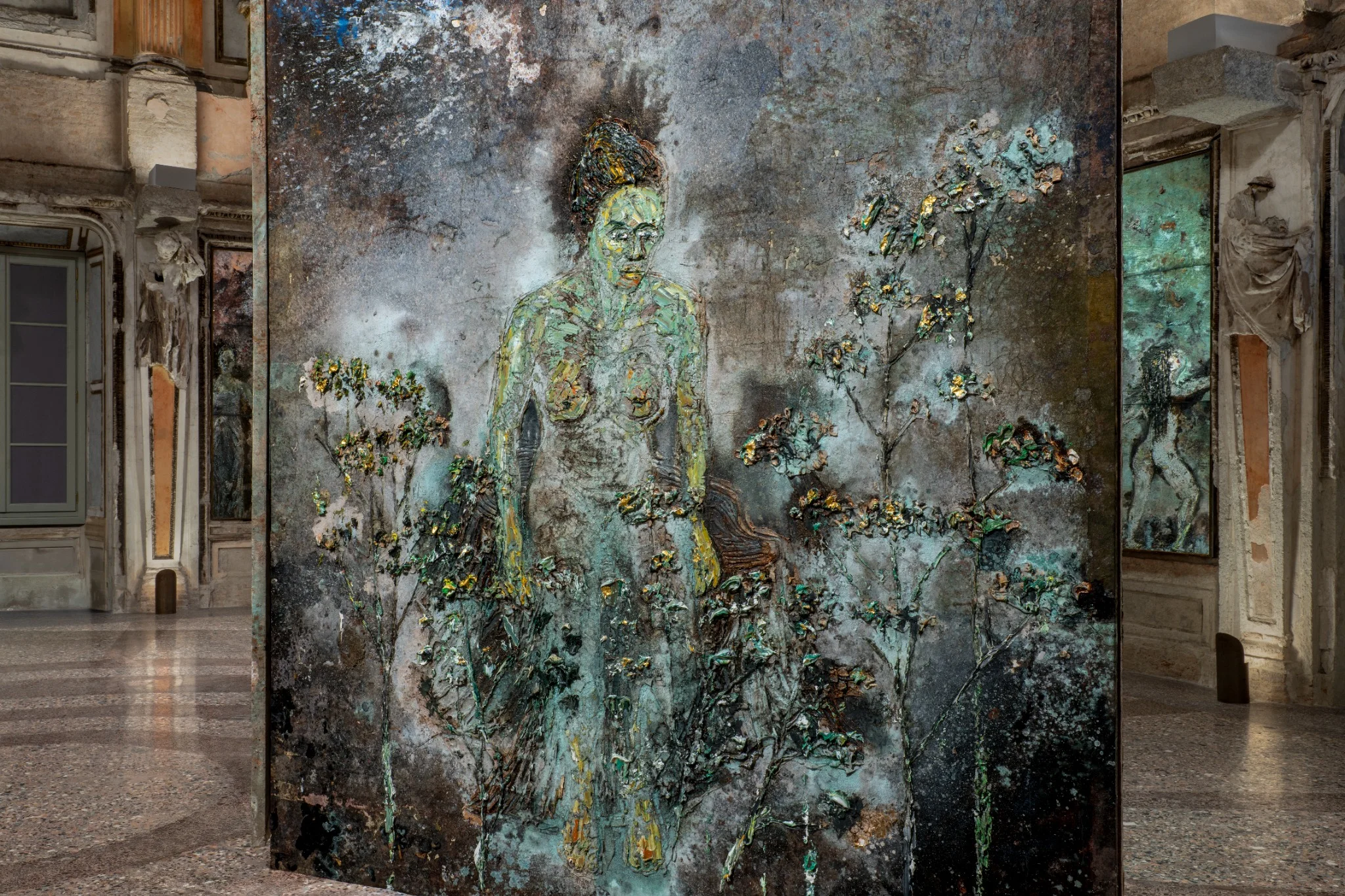 Installation view of Anselm Kiefer’s “The Women Alchemists” at Palazzo Reale, Sala delle Cariatidi, Milan, featuring large-scale textured panels with alchemical and figurative imagery.
