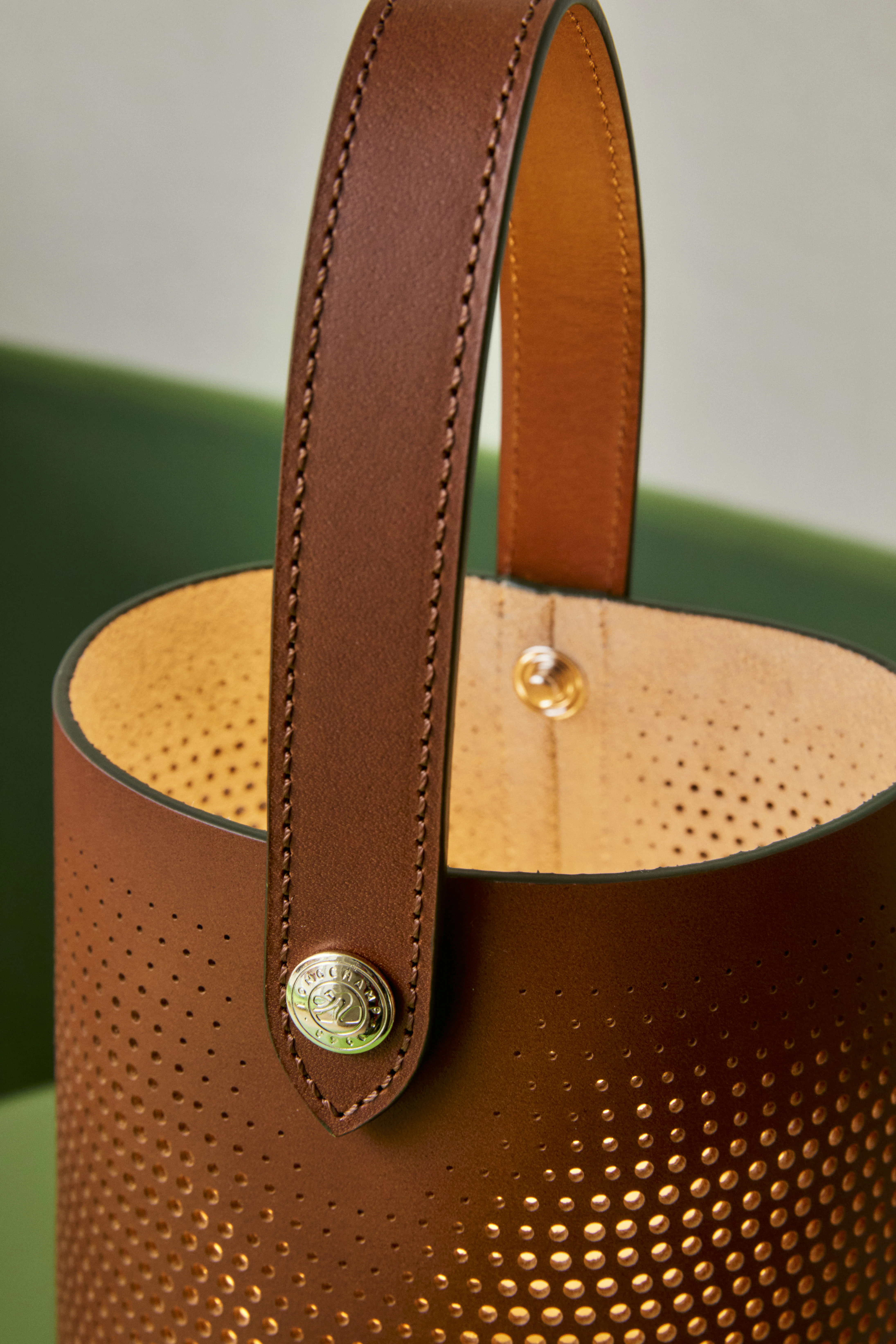 Longchamp x Patrick Jouin brown perforated leather bucket bag with gold logo hardware, Milan 2026