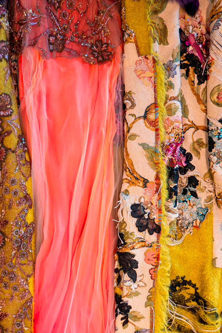 Dries Van Noten Foundation archive garments: coral chiffon gown beside embroidered floral brocade fabrics