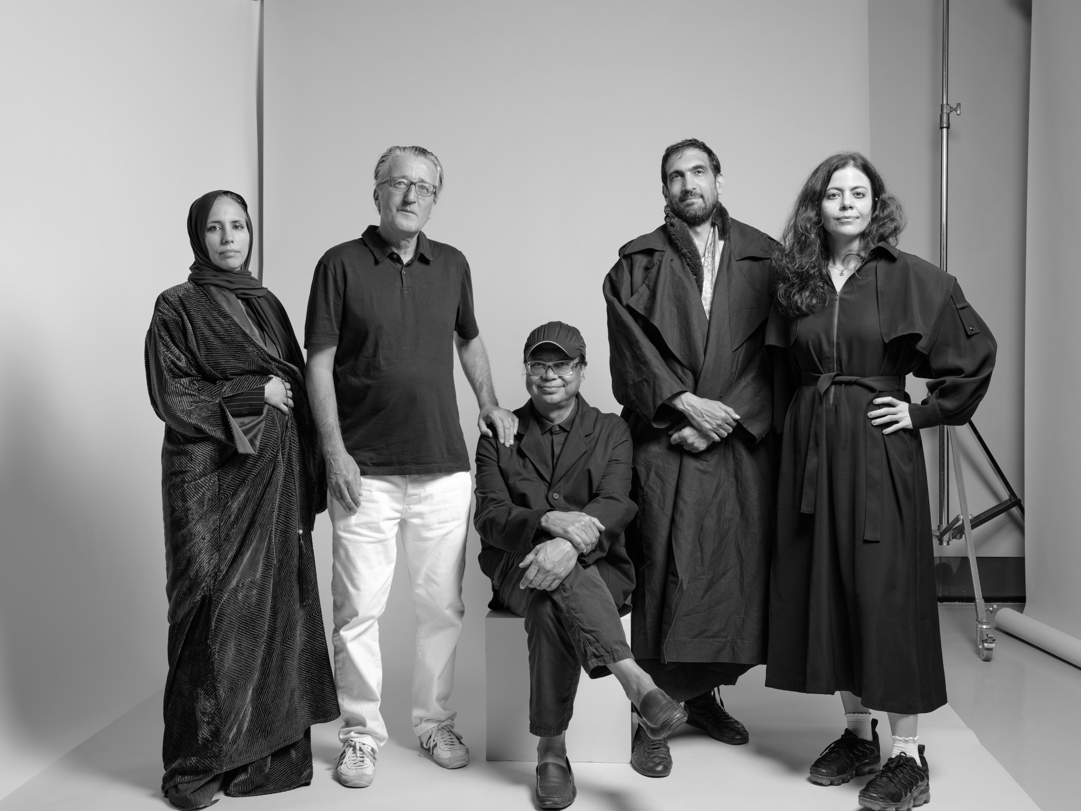Sophia Al-Maria, Tom Eccles, Rirkrit Tiravanija, Tarek Atoui, and Ruba Katrib posed in black-and-white studio portrait