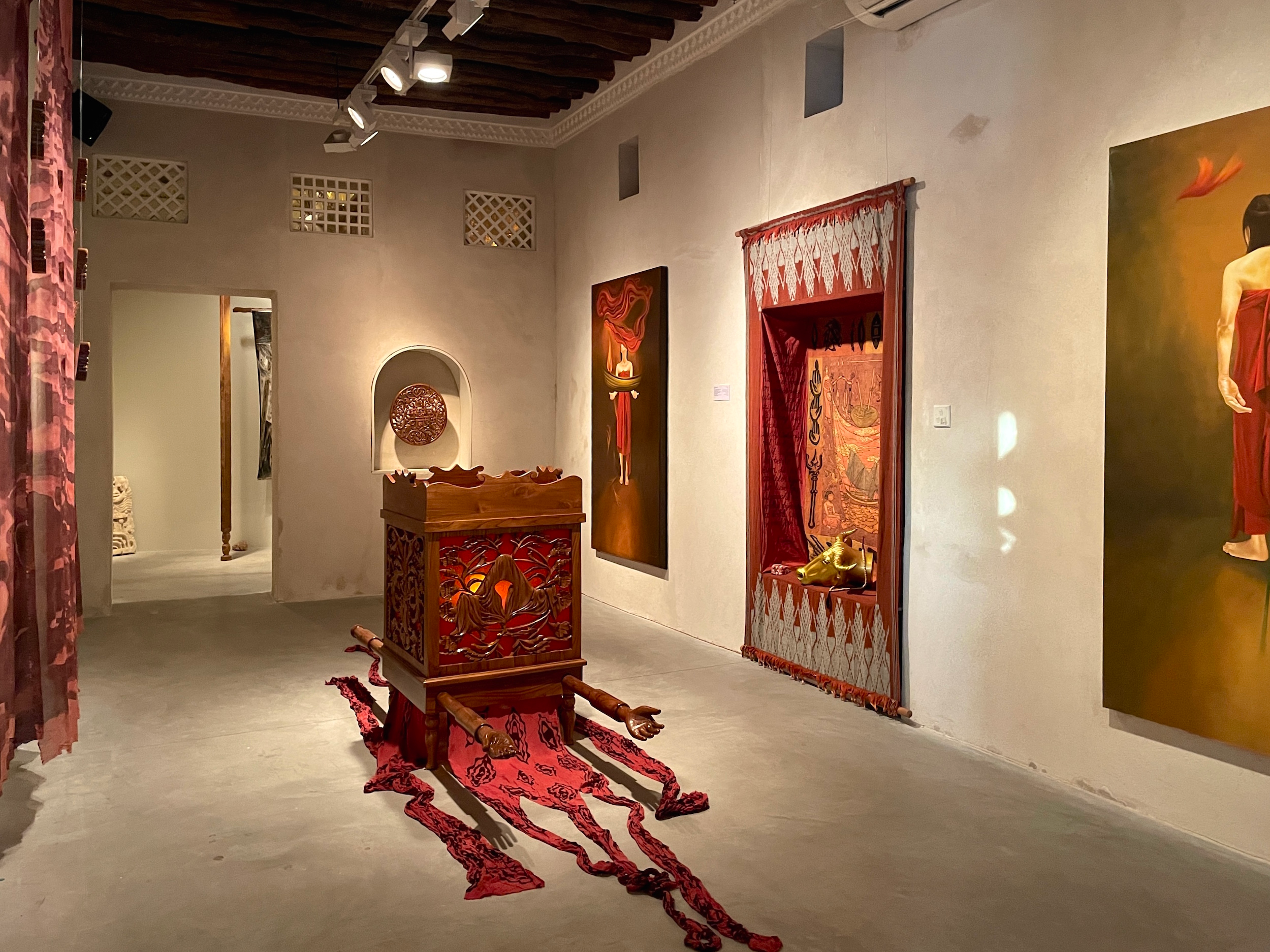 Dian Suci's Larung installation 2024, ornate wooden palanquin with red fabric and mixed media artworks